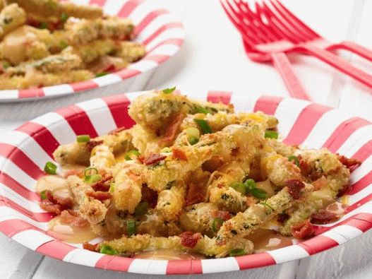 Foto de papas fritas de calabacín con salsa y queso