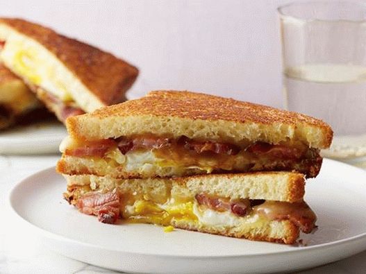 Foto Sandwich caliente con queso, tocino, huevo y jarabe de arce