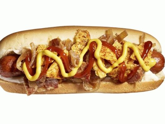 Foto de un hot dog con condimento de chile y tocino