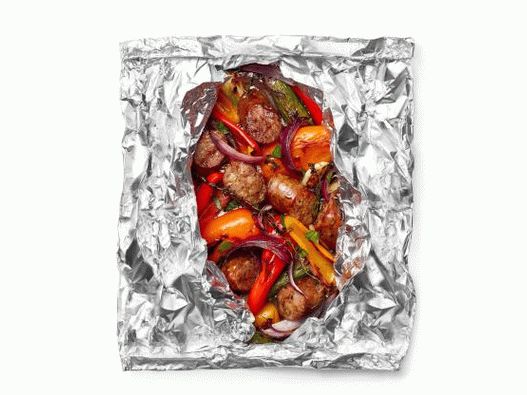 Foto de salchichas y pimientos con cerveza, fritos en papel de aluminio