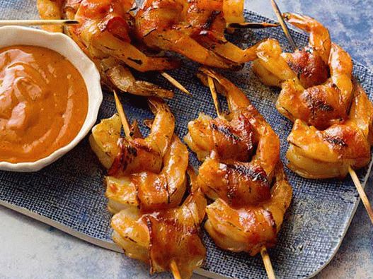 Foto de camarones envueltos en tocino, en el esmalte de una barbacoa