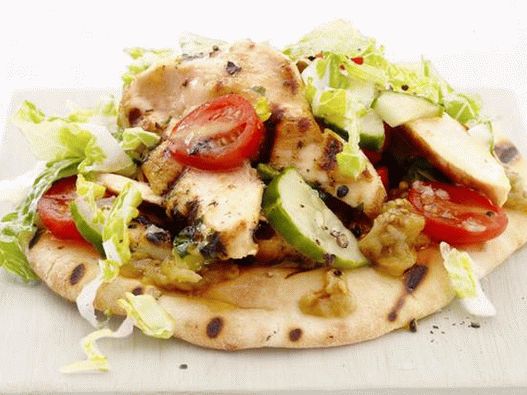 Ensalada sobre una tortilla con pechuga de pollo frita