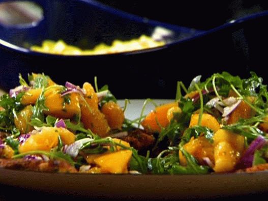 Foto de un pollo empanizado con rúcula y naranjas