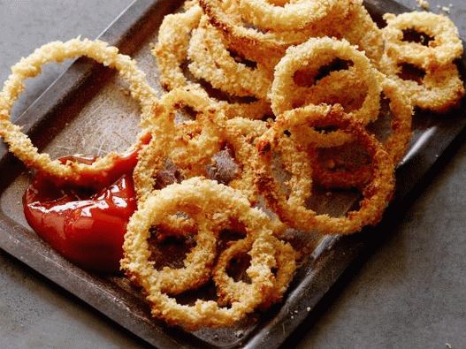 Foto aros de cebolla al horno en el horno