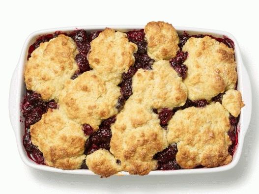 Foto de un zapatero de durazno con frambuesas debajo de una tapa de masa