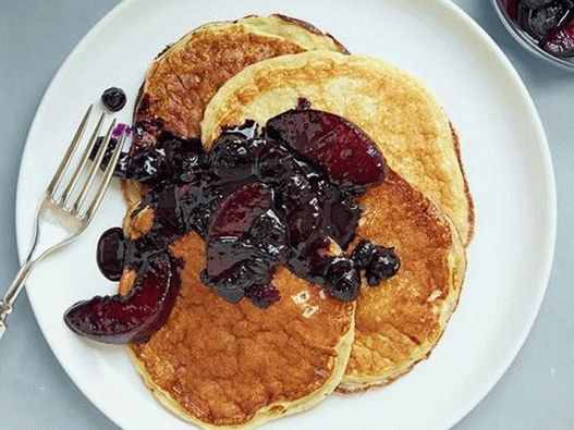 Foto de panqueques exuberantes sobre yogurt con salsa de arándanos y duraznos