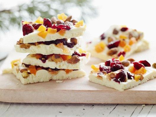 Foto Una barra de chocolate blanco con pistachos enteros, arándanos secos y albaricoques secos