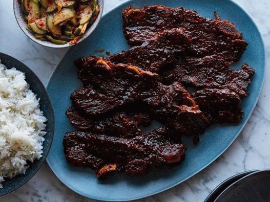 Costillas en una olla de cocción lenta y pepinos picantes coreanos