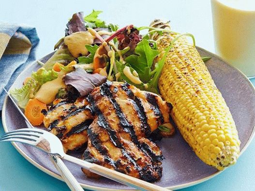 Pollo en salsa barbacoa con hojas de ensalada, maíz a la parrilla y batido