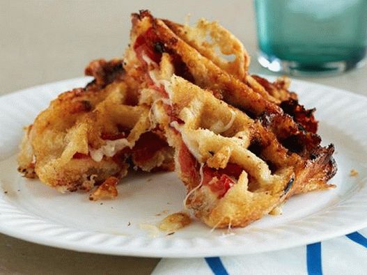 Foto Sandwiches con queso crema y tomates en una plancha para gofres