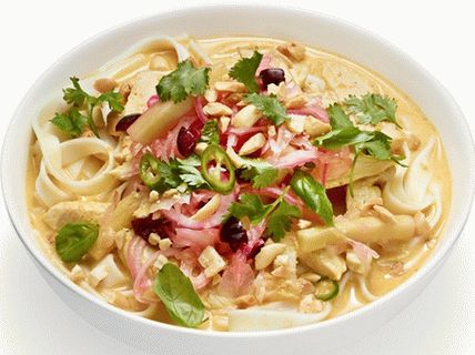 Foto sopa de curry con pollo, maní y verduras en escabeche