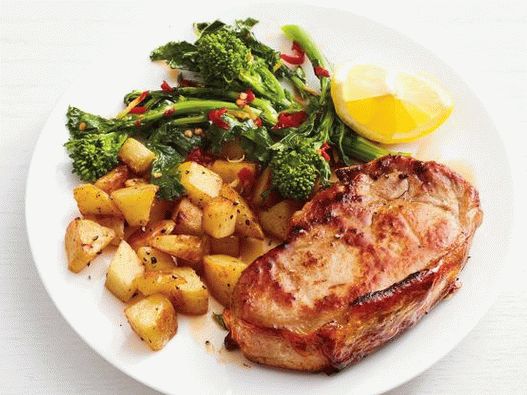 Foto Chuletas de cerdo con papas y brócoli de rapini