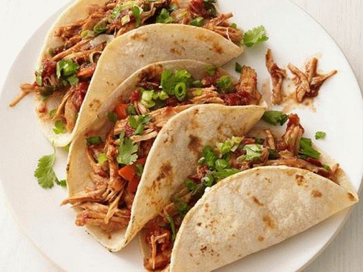 Foto de un Tacos con pavo en salsa de mole en una olla de cocción lenta