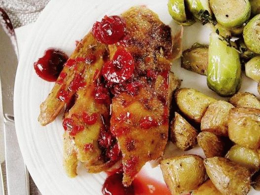 Pato al horno con una corteza crujiente en salsa de cereza y romero