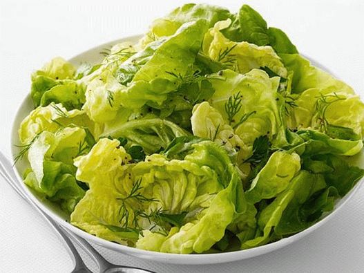 Foto de ensalada de verduras verdes con aderezo de limón y aceituna